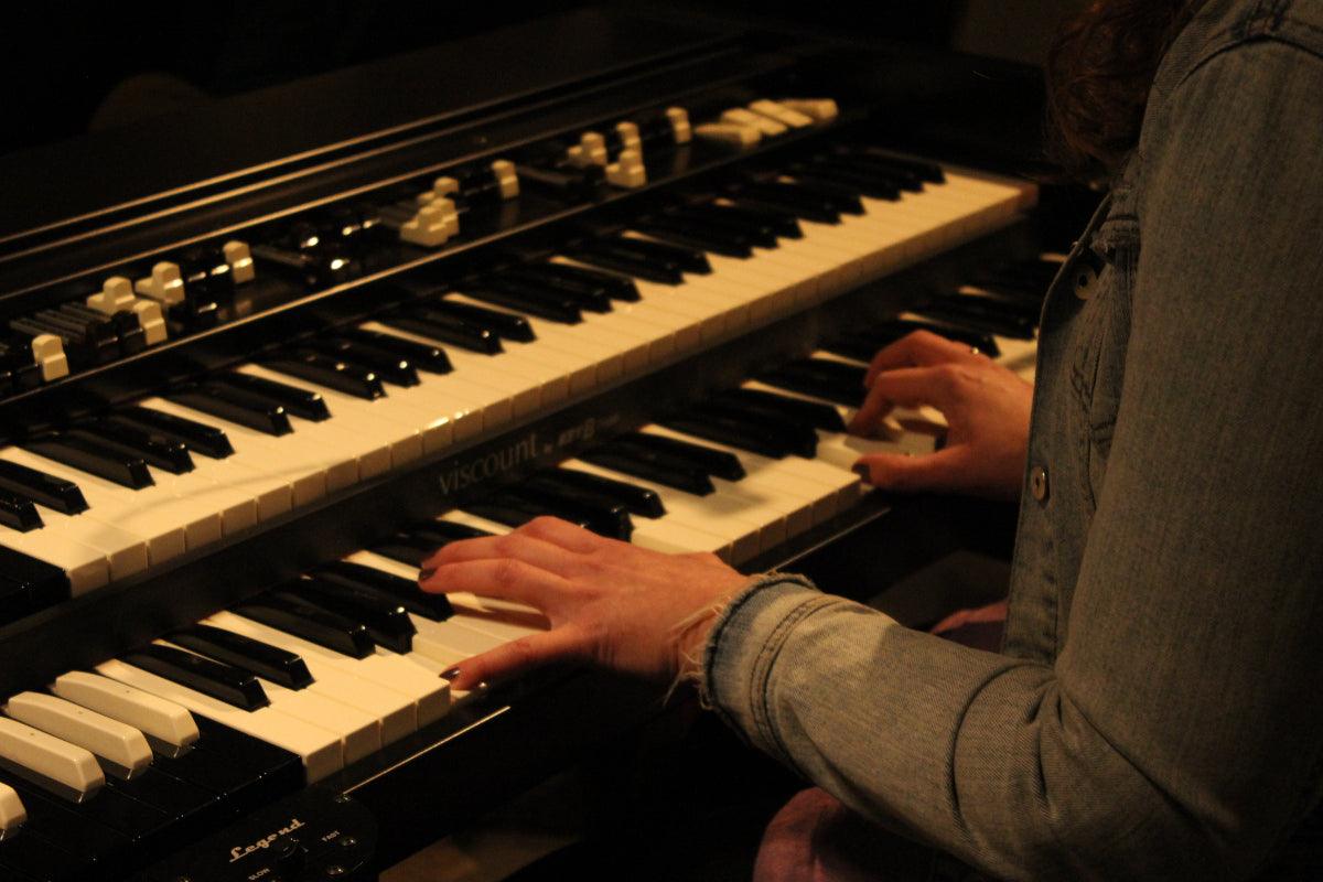 Frau in Jeansjacke spielt Vintage-E-Orgel, nachhaltiger Lifestyle bei Vintage Kontor