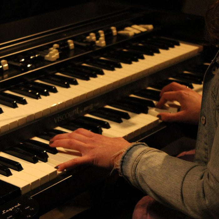 Frau in Jeansjacke spielt Vintage-E-Orgel, nachhaltiger Lifestyle bei Vintage Kontor
