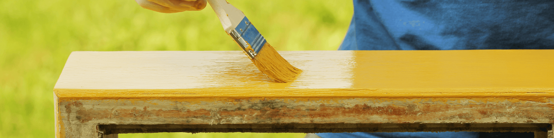 Hand streicht gelben Lack auf Vintage Holzmöbel im Garten, Upcycling bei Vintage Kontor